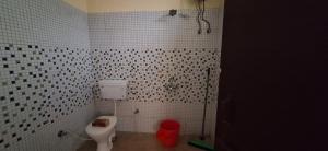 een badkamer met een toilet en een betegelde muur bij Pahadi Ghar in Bhīm Tāl