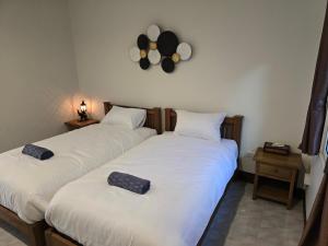 two beds sitting next to each other in a room at The Old City Rooms in Chiang Mai