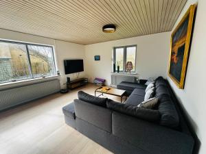 uma sala de estar com um sofá e uma televisão em Beautiful villa close to beach and nature em Hanstholm