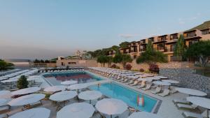 a hotel with a pool and chairs and umbrellas at Elios Hill in Hersonissos