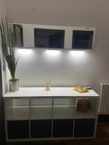 a white counter with two lights and a plant on it at Cube Apartments in Lytham St Annes