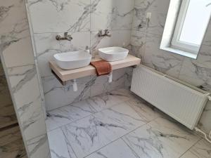 a bathroom with two sinks on a marble wall at Laguna ubytovanie 2 B in Nemšová