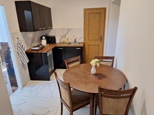 a small kitchen with a wooden table and chairs at Laguna ubytovanie 2 B in Nemšová