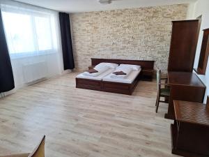 1 dormitorio con cama y pared de ladrillo en Laguna ubytovanie 2 B en Nemšová