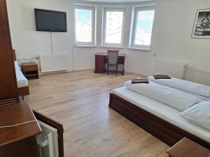 a bedroom with two beds and a tv on the wall at Laguna ubytovanie 2 B in Nemšová