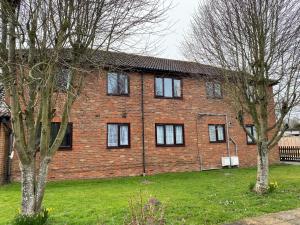 a brick house with black windows in a yard at Spacious Apartment - Contractors and Family - LGW in Horley
