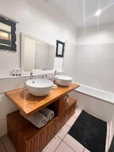 La salle de bains est pourvue de 2 lavabos, d'un miroir et d'une baignoire. dans l'établissement Duplex Ophélie, à Saint-Denis