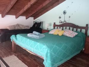 1 dormitorio con 2 camas y edredón verde en Rincón del Sol en Gardey