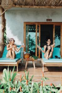 two women sitting on beds in a resort at Siam Cookies Cottage in Haad Pleayleam