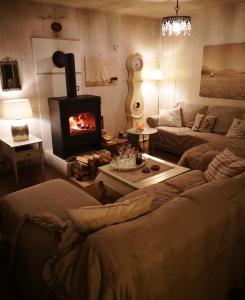 een woonkamer met een bank en een open haard bij Countryhouse Lake Attersee - Sauna, Kamin, Seeblick in Unterach am Attersee