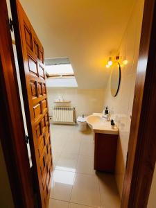 La salle de bains est pourvue d'un lavabo et de toilettes. dans l'établissement Casa Grande do Costureiro Portomarín Camino de Santiago Francés, à Portomarín