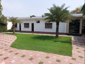 una casa con dos palmeras en el patio en Status Club Resort, en Kānpur