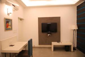 um quarto com uma televisão de ecrã plano na parede em Status Club Resort em Kanpur