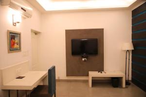 a room with a flat screen tv on a wall at Status Club Resort in Kānpur