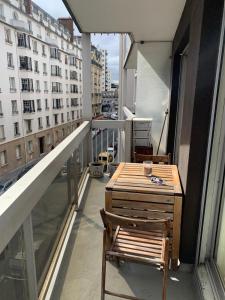 - un balcon avec une table et des chaises dans un bâtiment dans l'établissement APPARTEMENT + Parking 45m2 TOUR EIFFEL, à Paris