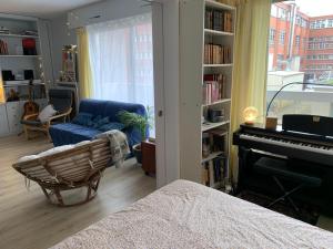uma sala de estar com um sofá e um piano em APPARTEMENT + Parking 45m2 TOUR EIFFEL em Paris