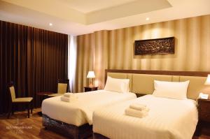 um quarto de hotel com duas camas com toalhas em Suvarnabhumi Ville Airport Hotel em Lat Krabang