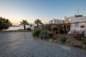 a house with a patio with a sunset in the background at Levantes House Mykonos in Ano Mera