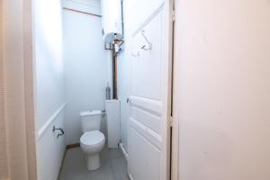 a white bathroom with a toilet and a door at Hypercenter flat, secure private parking in Fontainebleau