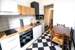 a kitchen with white cabinets and a table and a sink at Hypercenter flat, secure private parking in Fontainebleau