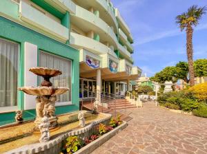 a building with a fountain in front of it at Hotel Losanna in Gabicce Mare