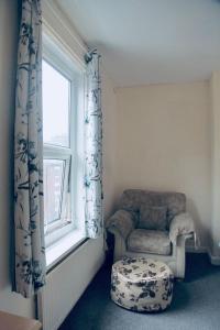 een kamer met een stoel en een raam bij PEACEFULLY AND CENTRALLY LOCATED DOUBLE BEDROOM in Hunslet