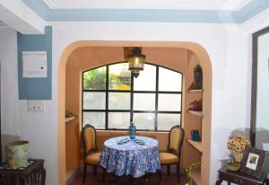a dining room with a table and chairs and a window at Casa Fontainhas in Panaji