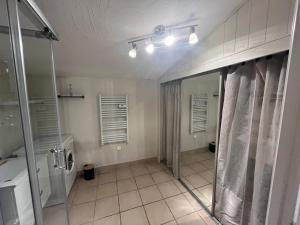 La salle de bains est pourvue d'une douche et d'une porte en verre. dans l'établissement La Maisonnette Le Portel plage, à Le Portel