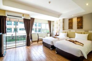 a hotel room with two beds and a large window at Suvarnabhumi Ville Airport Hotel in Lat Krabang