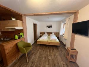um pequeno quarto com uma cama e uma televisão em Winkelhof em Oberstdorf