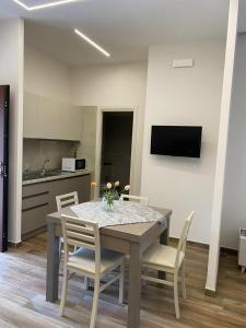 Villa Rose Apartments في Sant'Egidio del Monte Albino: طاولة طعام مع كراسي ومطبخ