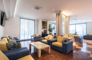 una sala de estar con sofás azules y una mesa. en Hotel Losanna, en Gabicce Mare