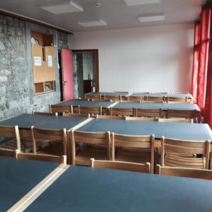 un aula vacía con mesas y sillas. en Gîte Les Cent Fontaines, en Modave