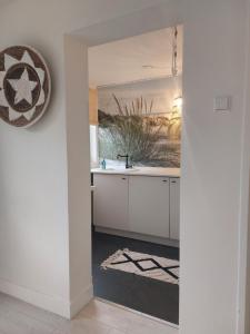 a kitchen with a sink and a mirror at Rembrandts beach view in Zandvoort