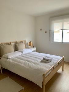 a bedroom with a large white bed with a window at Cosy apartment in Almuñecar in Almuñécar