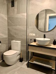 a bathroom with a toilet and a sink and a mirror at Cosy apartment in Almuñecar in Almuñécar +7 photos