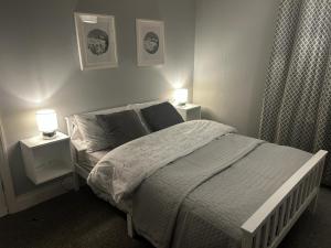 a bedroom with a bed with two nightstands and two lamps at Beautiful Bright Three Bedroom House in Brighton and Hove with free parking in Portslade