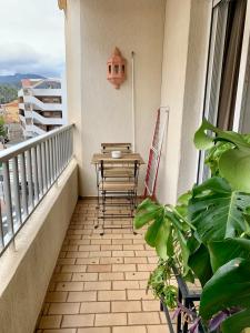 a table and chairs on a balcony with plants at Cosy apartment in Almuñecar in Almuñécar