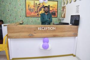 Ein Mann steht an der Rezeption in der Unterkunft Hotel Karan International ,Aurangabad in Aurangabad
