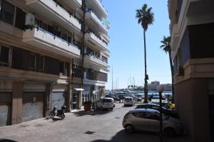 ulica miejska z samochodami zaparkowanymi na parkingu w obiekcie Ortigia Riflessa - design e comfort vista mare w Syrakuzach