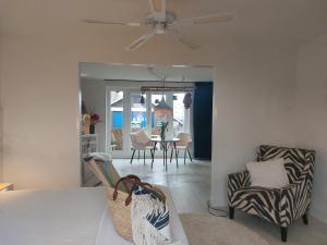 a living room with a table and chairs and a ceiling fan at Rembrandts beach view in Zandvoort