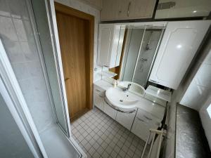 a small bathroom with a sink and a mirror at Gästehaus Bockenem - Monteurzimmer in Bockenem