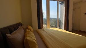 a bed in a room with a large window at Sun Dove Suite in Kandy