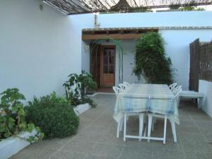 a patio with a table and chairs in front of a building at Casa los Cactus in Playa Migjorn