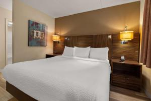 a large bed in a hotel room with two lights at Ramada by Wyndham Harrisburg/Hershey Area in Harrisburg