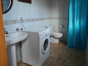 a bathroom with a washing machine and a sink at Casa los Cactus in Playa Migjorn