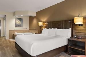 ein großes weißes Bett in einem Hotelzimmer in der Unterkunft Ramada by Wyndham Harrisburg/Hershey Area in Harrisburg