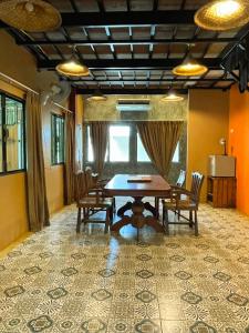 une salle à manger avec une table et des chaises en bois dans l'établissement Baibon1 Boutique House Thalang Phuket, à Ban Na Nai
