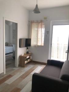 a living room with a couch and a flat screen tv at Céntrico Rota Beach. in Rota