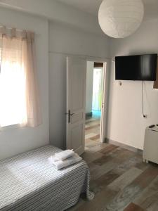 a bedroom with a bed and a flat screen tv at Céntrico Rota Beach. in Rota +14 photos